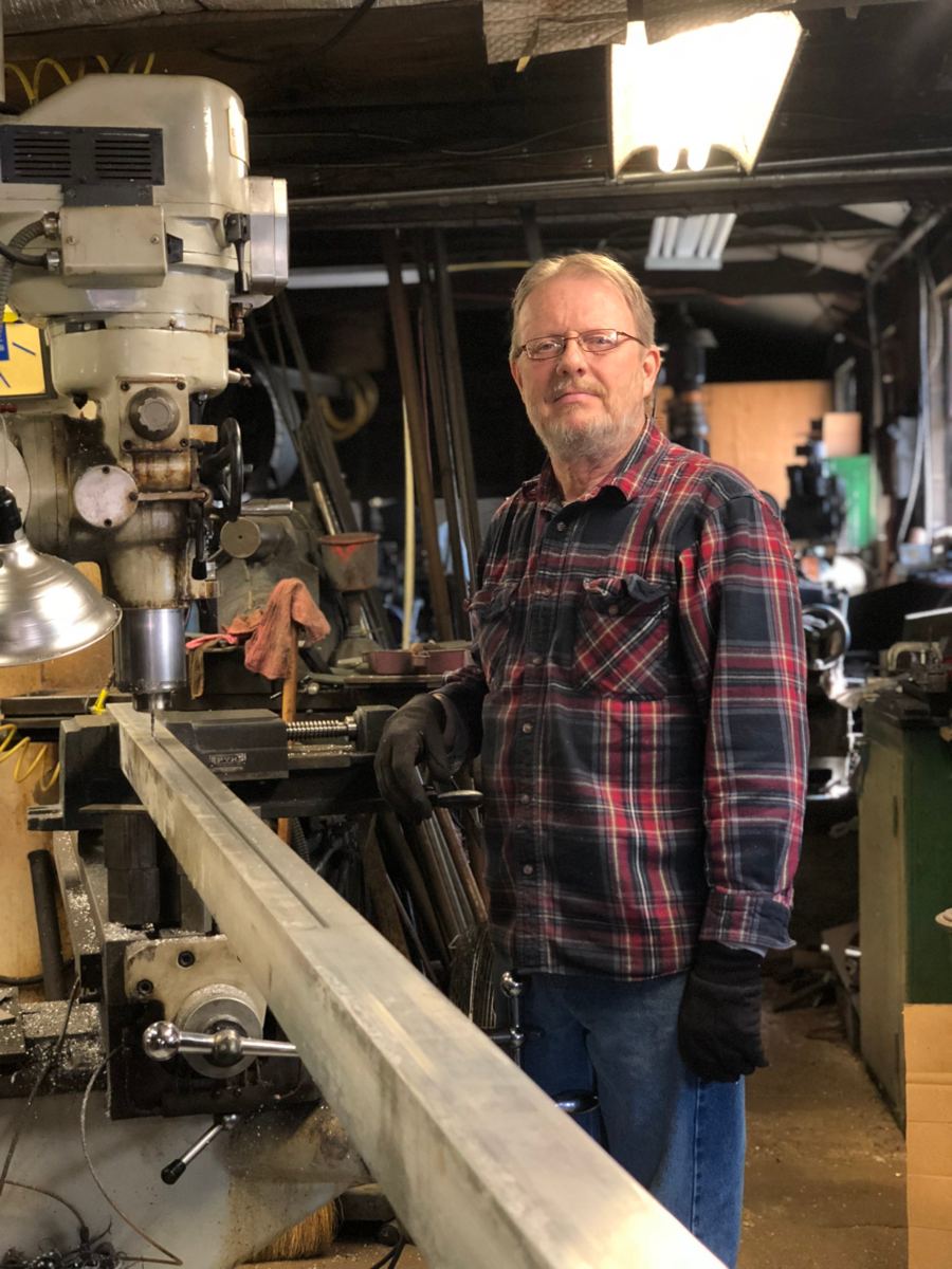 The owner of Crawford Machine standing beside the vertical mill in the Titusville shop